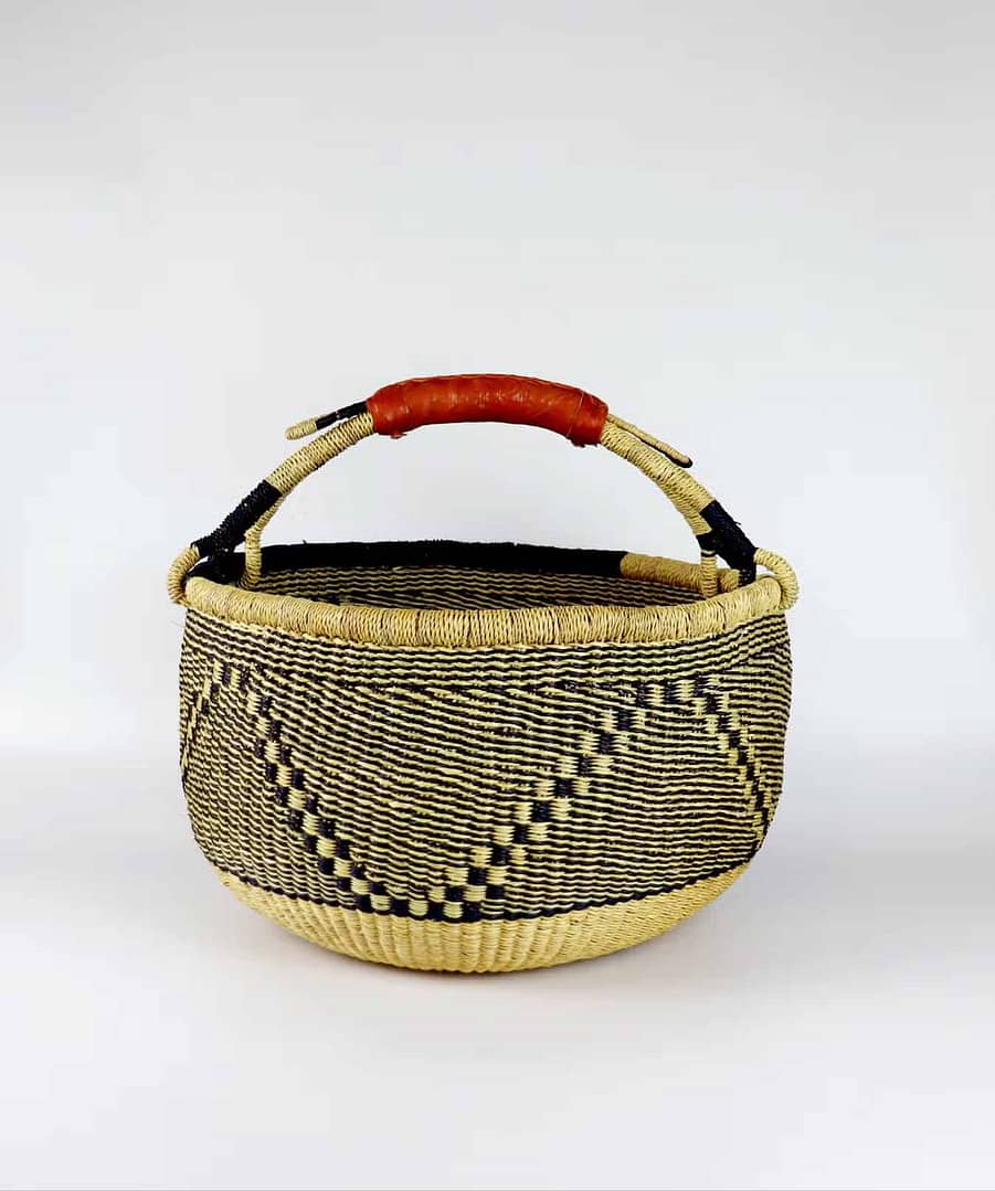 black and natural straw coloured bolga basket with a red leather handle
